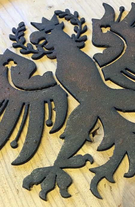 Dekorativer Tiroler Adler in Metalloptik auf Holzoberfläche